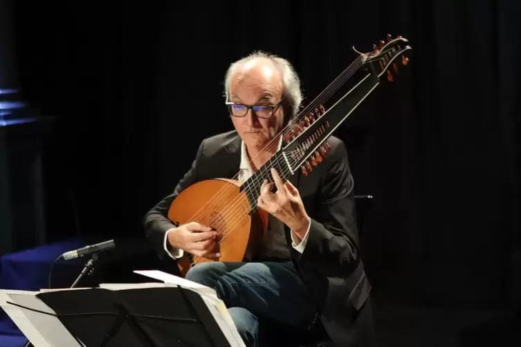 Andreas Martin tocando la tiorba en un escenario oscuro